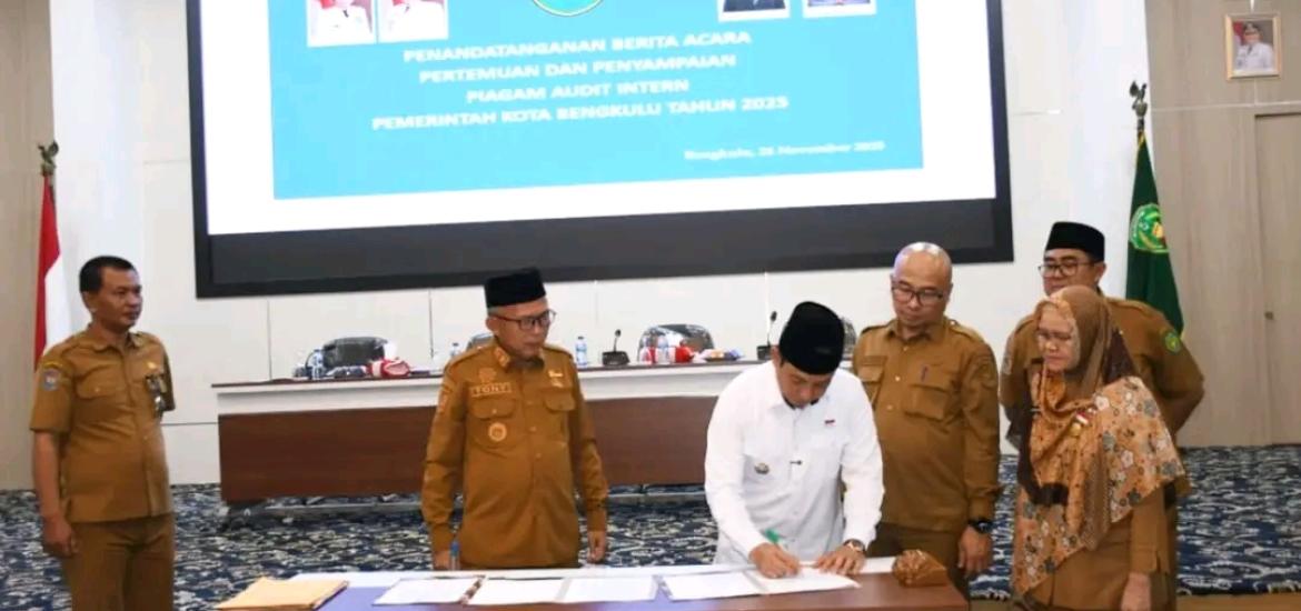 menandatangani Berita Acara Pertemuan dan Penyampaian Piagam Audit Intern Pemkot Bengkulu Tahun 2025.