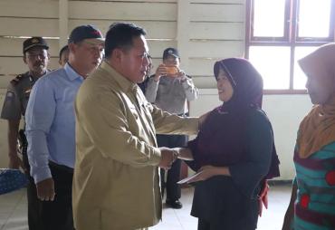 Bupati Mukomuko Choirul Huda saat menyerahkan bantuan PKH